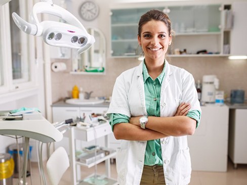 Dentist proudly smiling in treatment room