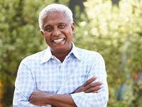 Man with dentures smiling outdoors