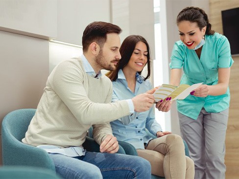 A couple speaking with a dental office member