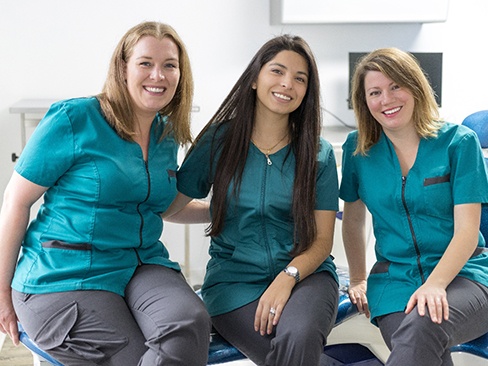 Three smiling dental team members