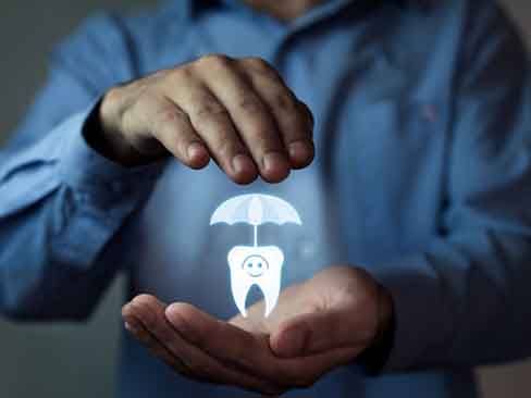 a person covering a symbol for dental insurance