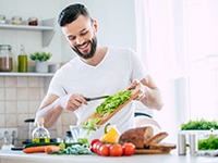 Smiling man preparing meal in kitchen at home