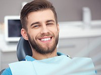 Man smiling while sitting in dentist’s treatment chair