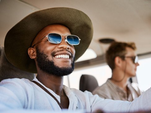 Man with sunglasses driving with friend