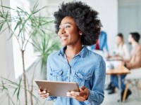 Woman smiling while holding tablet in office