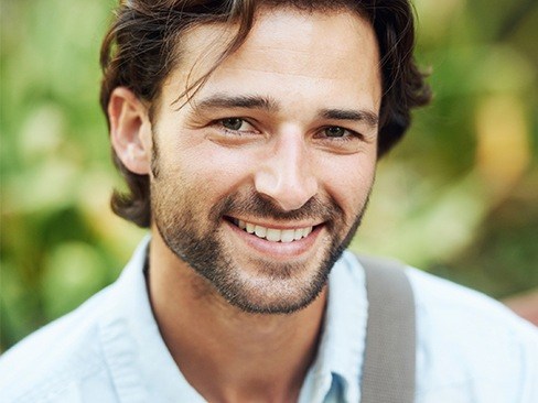 Man with attractive smile after porcelain veneers