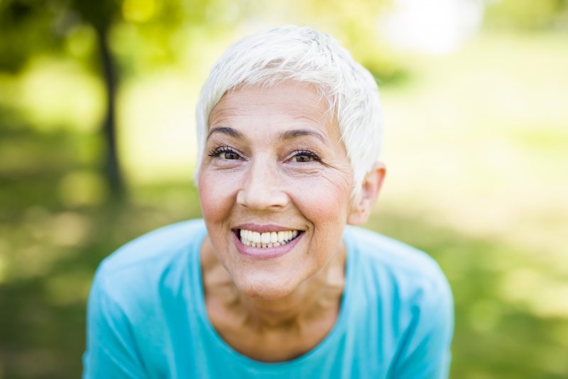 A smiling and sporty senior woman in a park