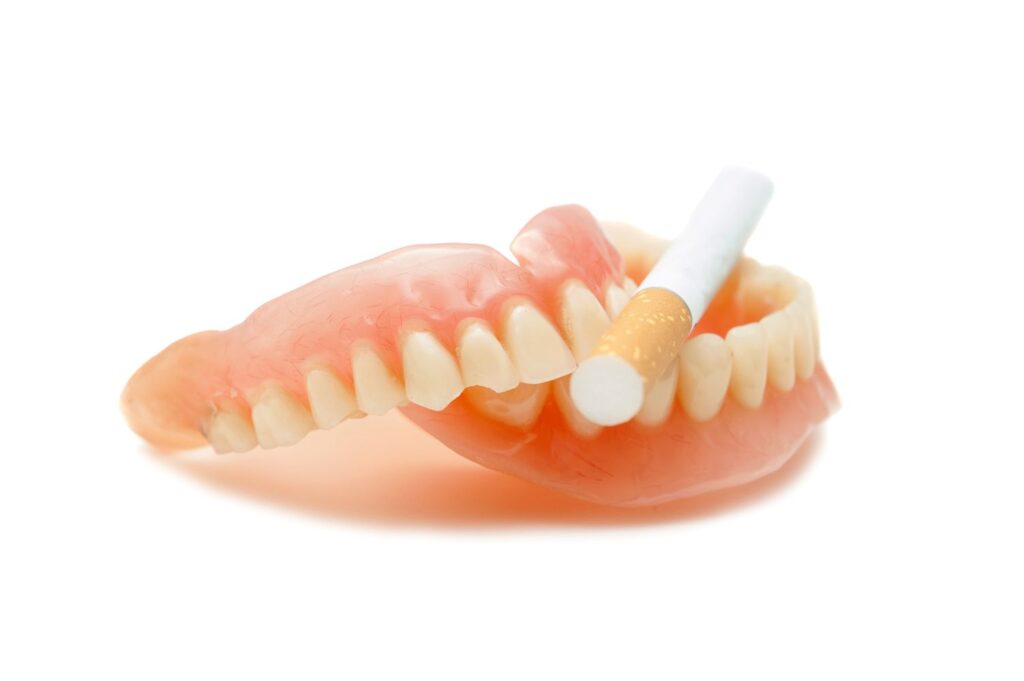 Cigarette resting between and upper and lower arch of dentures